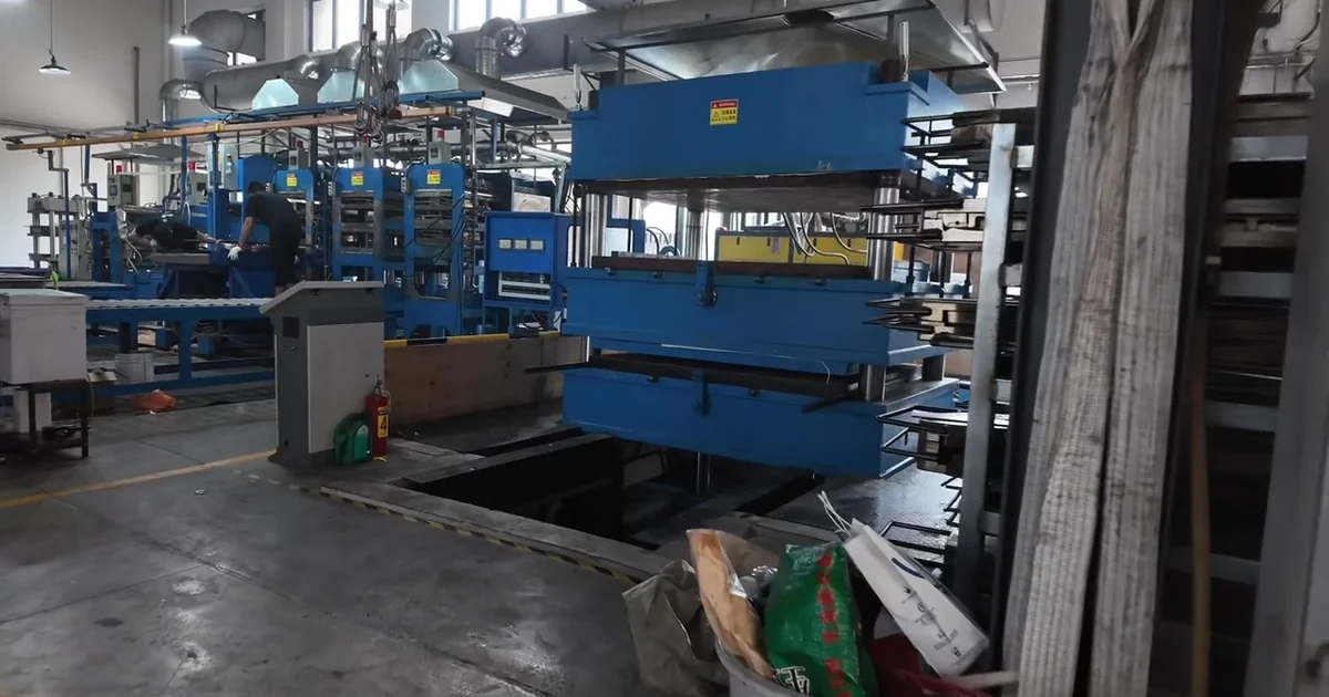 Compression molding equipment inside the Vuro Carbon carbon fiber parts factory.